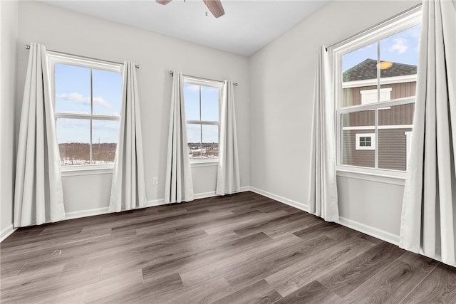 empty room with ceiling fan and dark hardwood / wood-style flooring