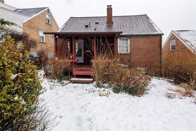 view of snow covered back of property