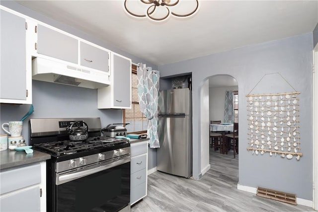 kitchen with white cabinets, light wood-type flooring, and appliances with stainless steel finishes