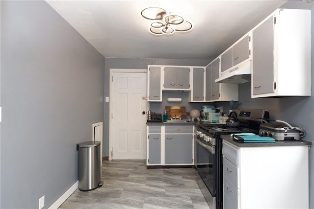 kitchen with gray cabinets, stainless steel range with gas cooktop, and hardwood / wood-style floors