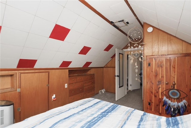 unfurnished bedroom featuring dark colored carpet, vaulted ceiling, and wood walls