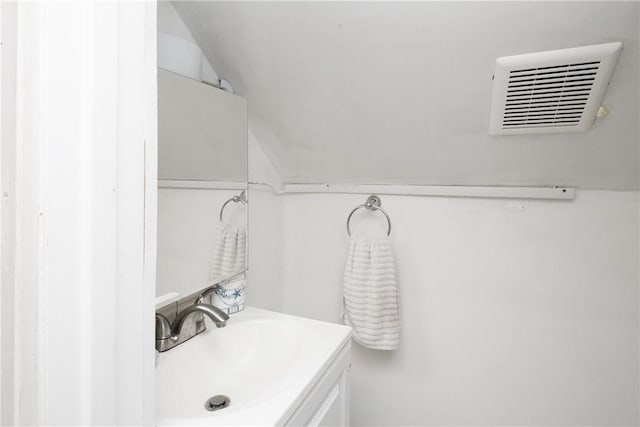 bathroom with vanity and lofted ceiling