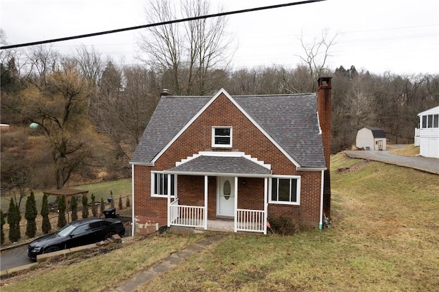 view of front of home featuring a storage unit and a front yard