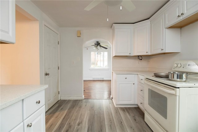 kitchen with ceiling fan, white range with electric cooktop, white cabinets, and light hardwood / wood-style flooring