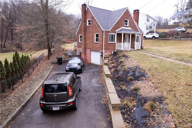 view of front facade with covered porch, a garage, and a front lawn