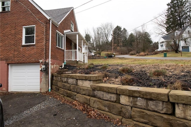 view of side of home featuring a garage and a porch