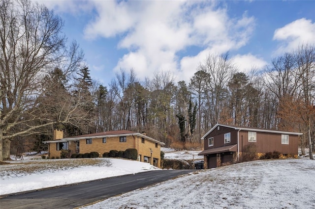 view of front of house with a chimney, driveway, and a garage