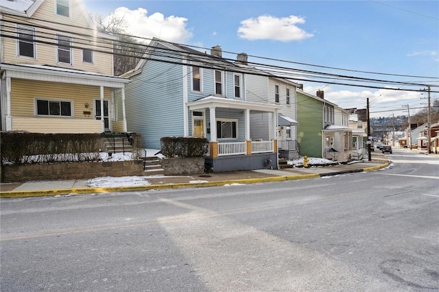 view of property with covered porch and a residential view