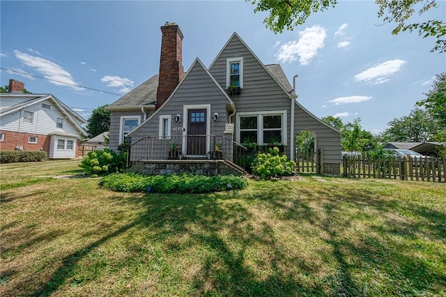 view of front of house with a front yard, a chimney, and fence