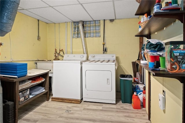 laundry area with light wood-style flooring, laundry area, washing machine and clothes dryer, and concrete block wall