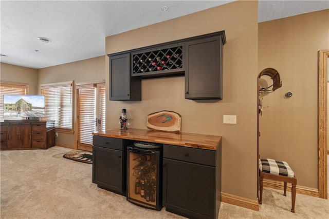 bar featuring wine cooler, wood counters, and light carpet