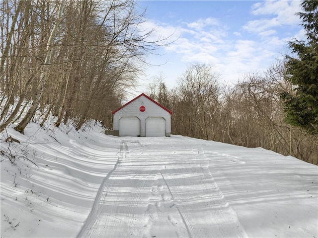 snow covered structure with a garage