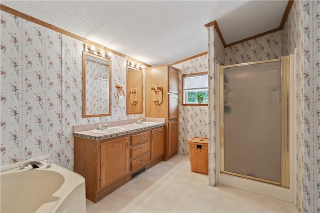 bathroom with ornamental molding, independent shower and bath, vanity, and a textured ceiling