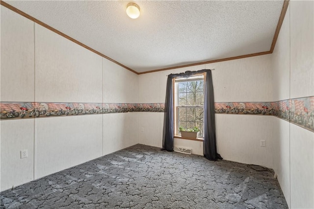 carpeted spare room with a textured ceiling and crown molding