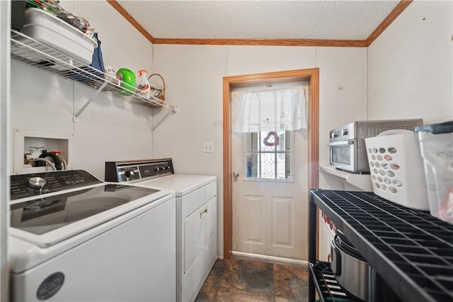 washroom featuring a textured ceiling, washer and clothes dryer, and ornamental molding