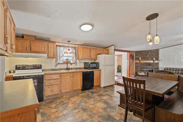 kitchen featuring a large fireplace, black appliances, a textured ceiling, pendant lighting, and sink