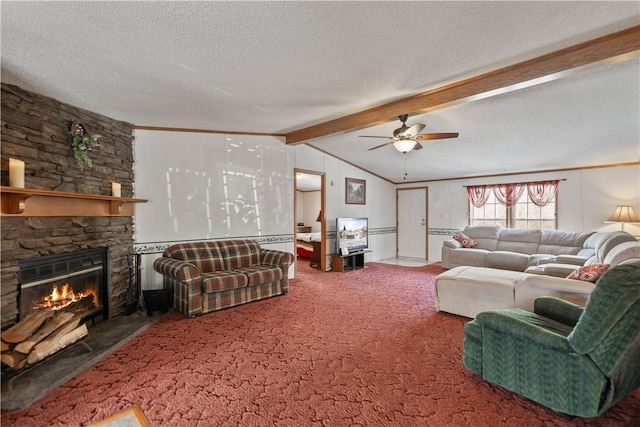 carpeted living room featuring a textured ceiling, a stone fireplace, ceiling fan, crown molding, and vaulted ceiling with beams