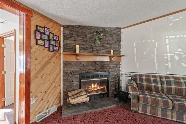 living room with carpet, wooden walls, a textured ceiling, and a fireplace