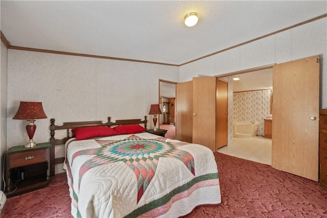 carpeted bedroom featuring ensuite bath and crown molding