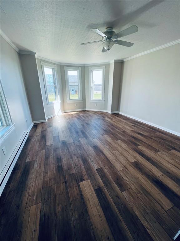 unfurnished room featuring crown molding, dark wood-style floors, and baseboards