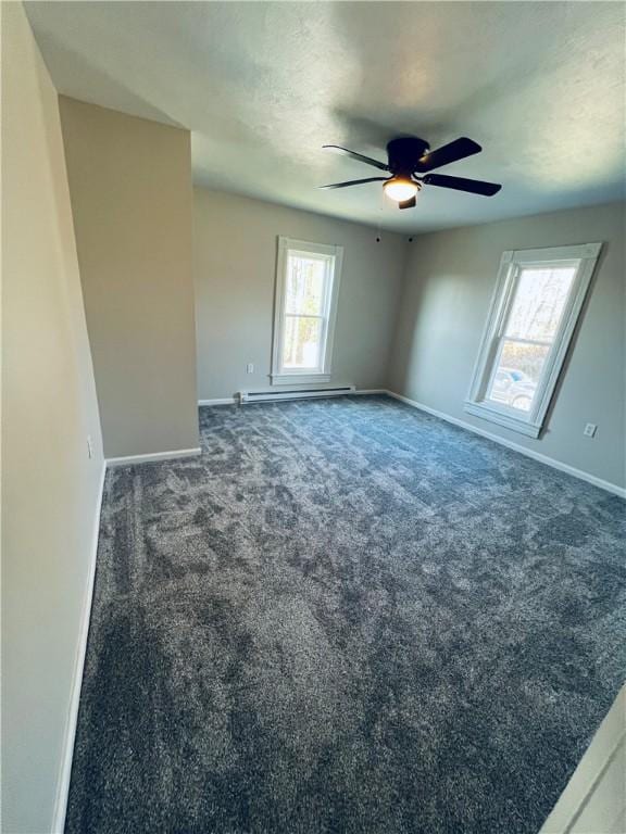 empty room featuring baseboards, dark colored carpet, and a ceiling fan