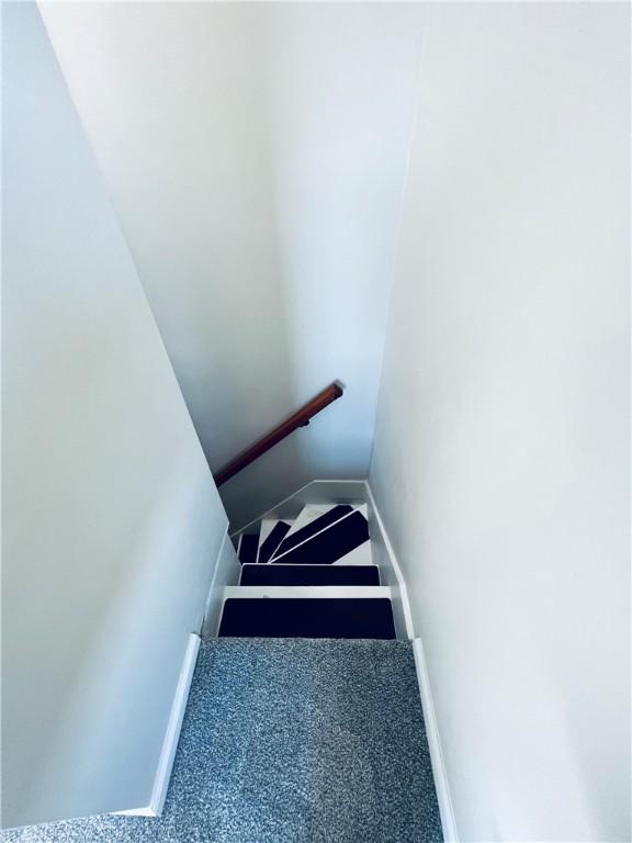 stairs featuring baseboards and carpet flooring