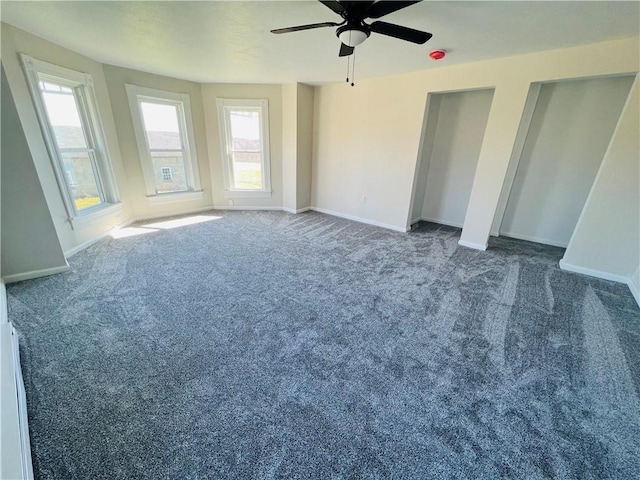 unfurnished bedroom featuring a ceiling fan, baseboards, and dark carpet