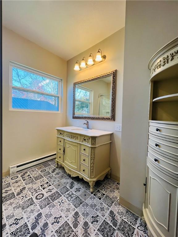 bathroom with a baseboard radiator, baseboards, vanity, and tile patterned flooring