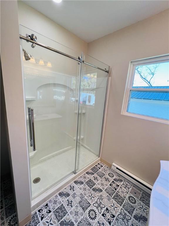 bathroom featuring a stall shower, a baseboard heating unit, and tile patterned floors