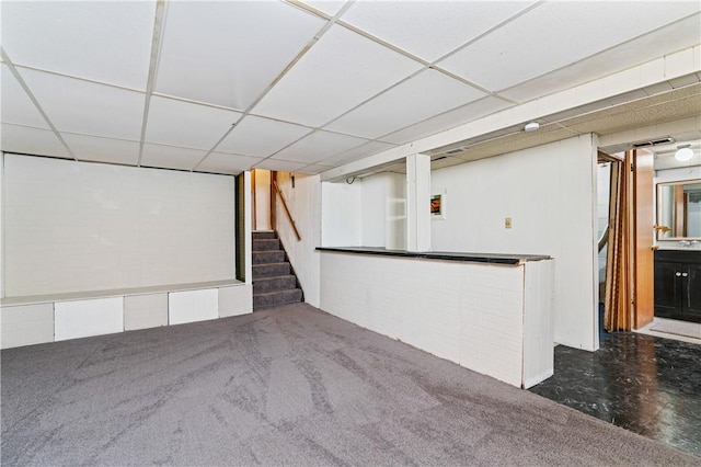 interior space with carpet flooring, a dry bar, and a paneled ceiling