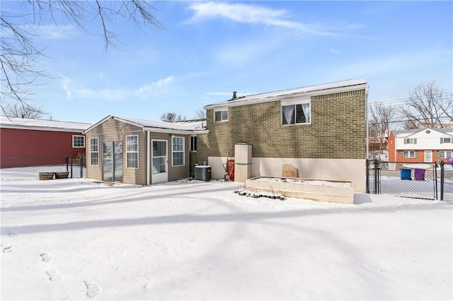 snow covered back of property featuring fence and central air condition unit