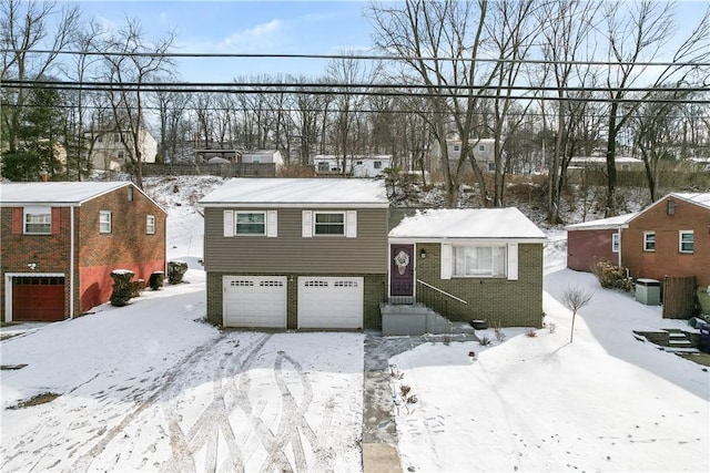 split level home featuring brick siding and a garage