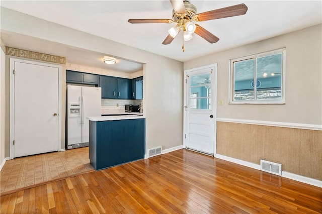 kitchen featuring light wood-type flooring, visible vents, and white refrigerator with ice dispenser
