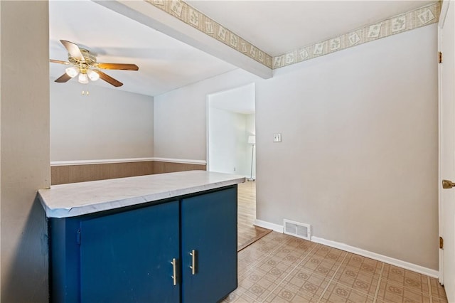 kitchen featuring light countertops, visible vents, a peninsula, blue cabinetry, and ceiling fan