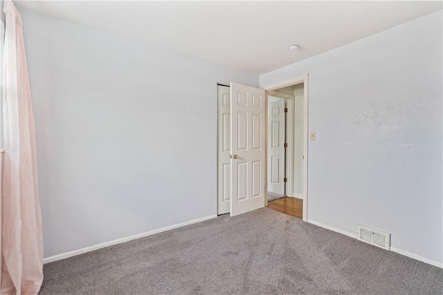 unfurnished room featuring baseboards, carpet flooring, and visible vents
