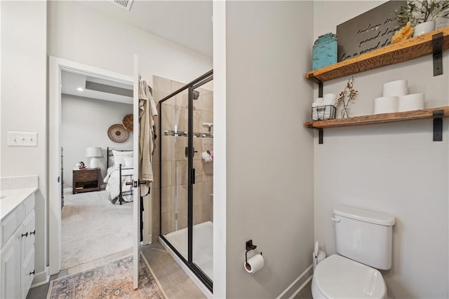 bathroom with vanity, toilet, ensuite bathroom, and a stall shower