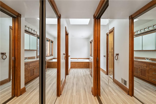 169 Clearview Rd, Raccoon Twp, PA 15001 - hall featuring a skylight, a sink, visible vents, and light wood-type flooring