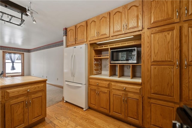 169 Clearview Rd, Raccoon Twp, PA 15001 - kitchen with light wood-style floors, tile countertops, freestanding refrigerator, brown cabinetry, and stainless steel microwave