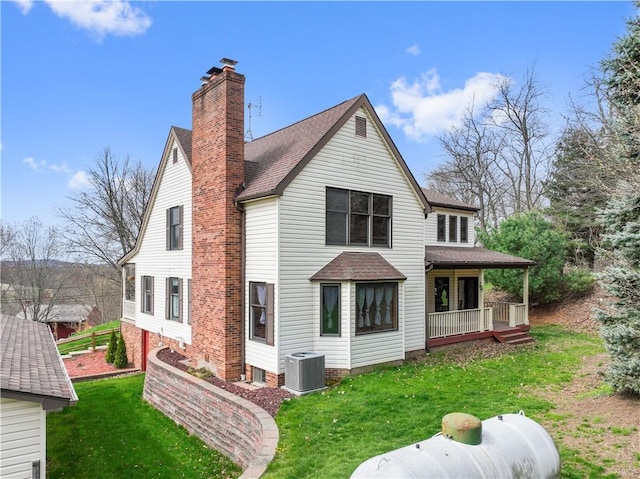 169 Clearview Rd, Raccoon Twp, PA 15001 - rear view of house featuring a shingled roof, central AC unit, a chimney, and a lawn