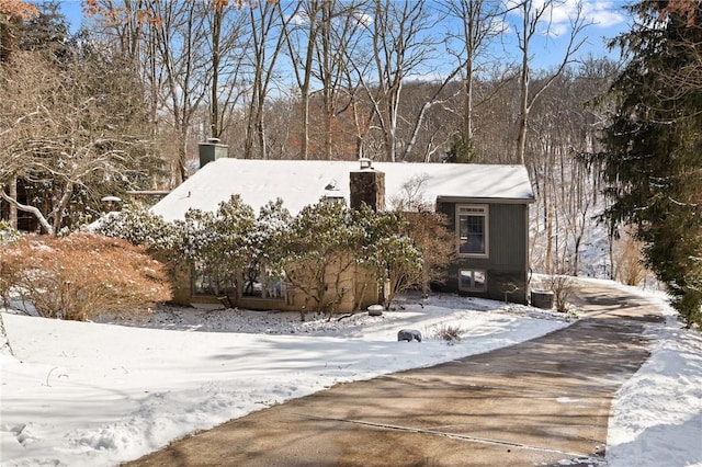 view of front of home featuring central AC and a chimney