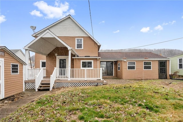 back of property with a yard and a wooden deck