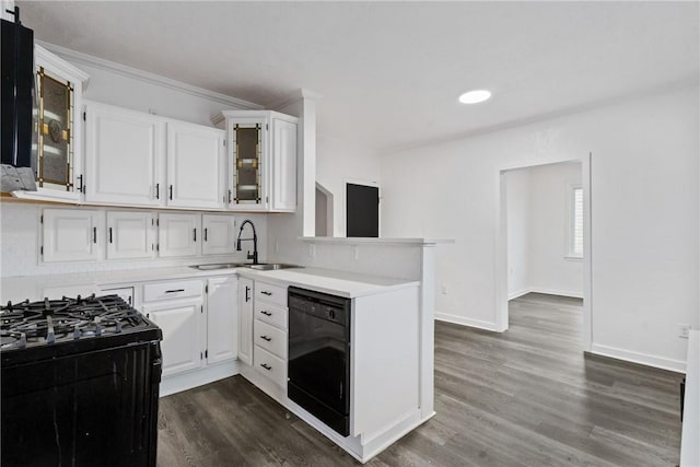 kitchen with white cabinets, glass insert cabinets, light countertops, black appliances, and a sink