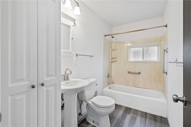 full bath with a sink, shower / bath combination, wood finished floors, and toilet