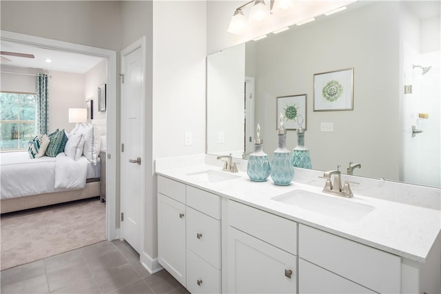 ensuite bathroom with ensuite bathroom, double vanity, tile patterned flooring, and a sink