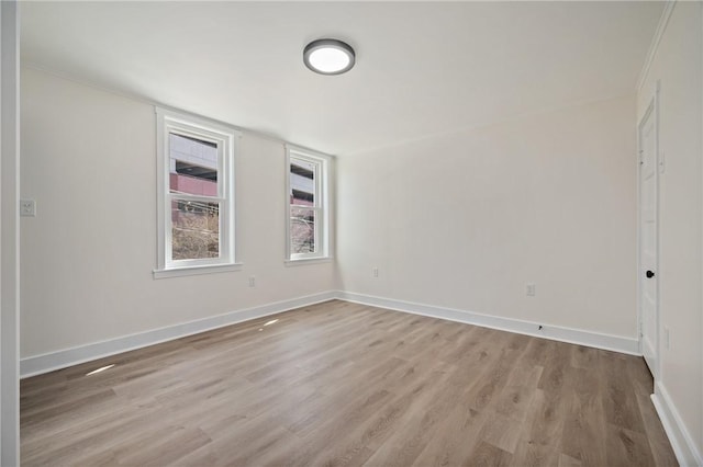 unfurnished room with light wood-style flooring and baseboards