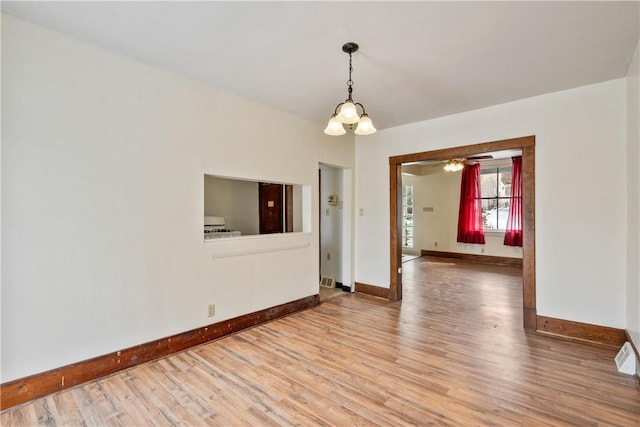 spare room with baseboards and wood finished floors