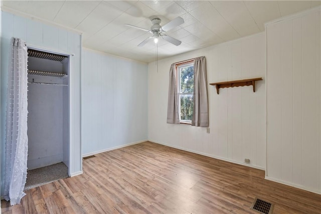 unfurnished bedroom with visible vents, crown molding, light wood-style flooring, and ceiling fan