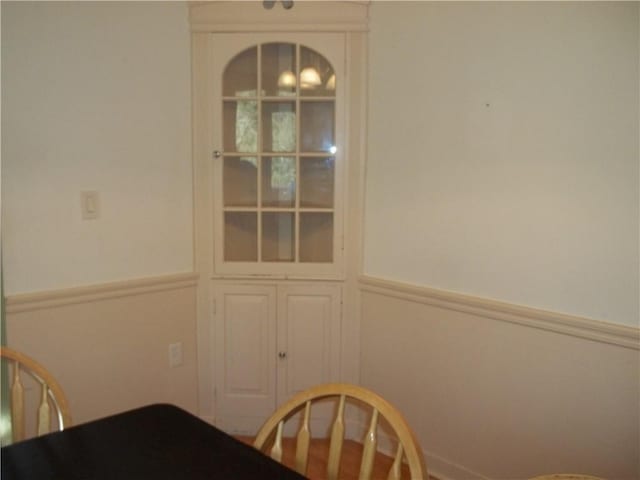 unfurnished dining area featuring a wainscoted wall