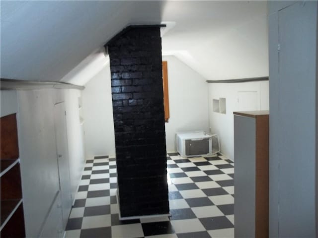 bonus room with dark floors and lofted ceiling