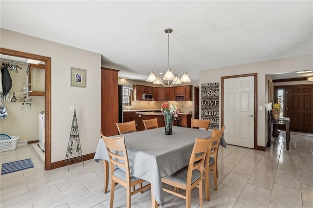 dining room with light tile patterned floors, baseboards, and a notable chandelier